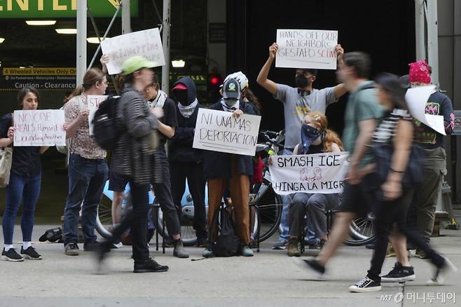 16일(현지 시간) 미 일리노이주 시카고 이민법원 앞에서 시위대가 이민세관단속국(ICE)을 욕하는 내용(Chinga La Migra) 등이 적힌 손팻말을 들고 모여 있다. /AP=뉴시스