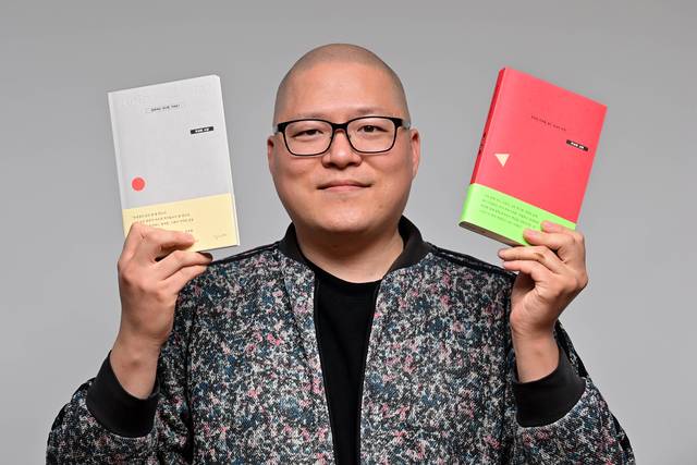 유성원 작가가 첫 소설 ‘성원씨는 어디로 가세요?’(왼쪽)와 산문 ‘토요일 외로움 없는 삼십대 모임’을 양손에 들고 있다.  문호남 기자