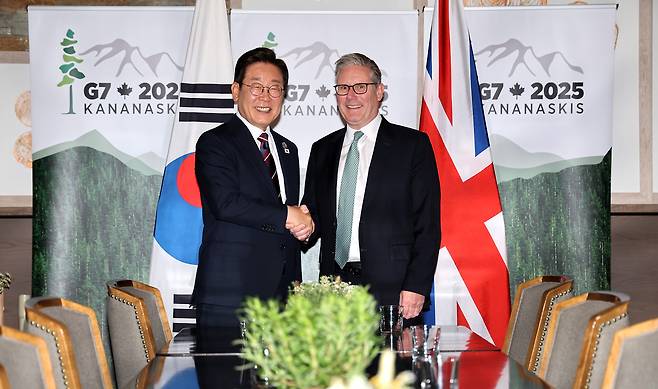 이재명 대통령이 17일(현지시간) 캐나다 앨버타주 캐내내스키스 주요 7개국(G7) 정상회의장에서 키어 스타머 영국 총리와 한영 정상회담 전 악수하고 있다. [연합]