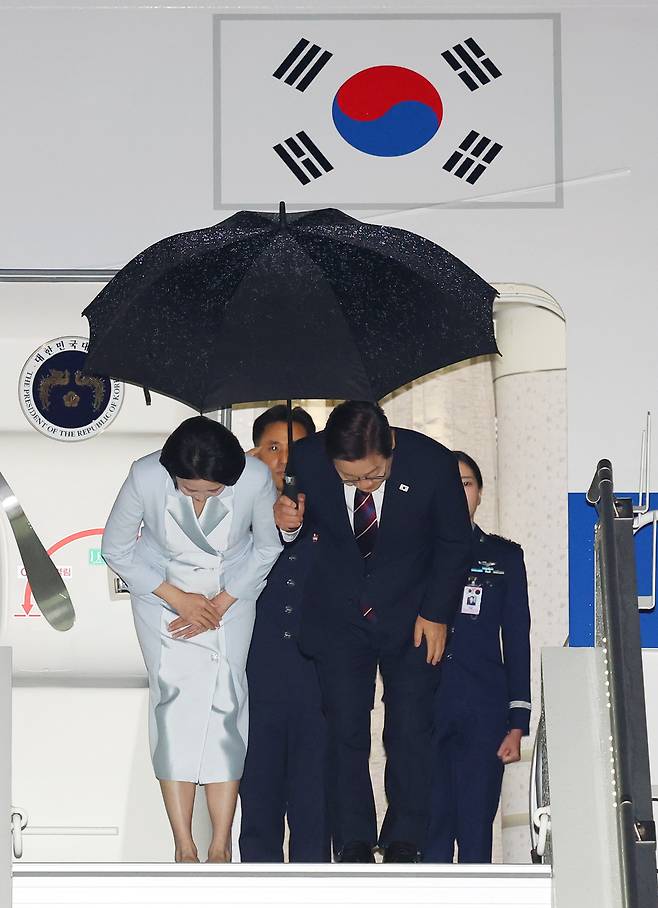 이재명 대통령과 김혜경 여사가 17일(현지시간) 51차 주요 7개국(G7) 정상회의 일정을 마치고 캐나다 캘거리 국제공항에서 귀국하며 공군 1호기 올라 인사하고 있다. [연합]