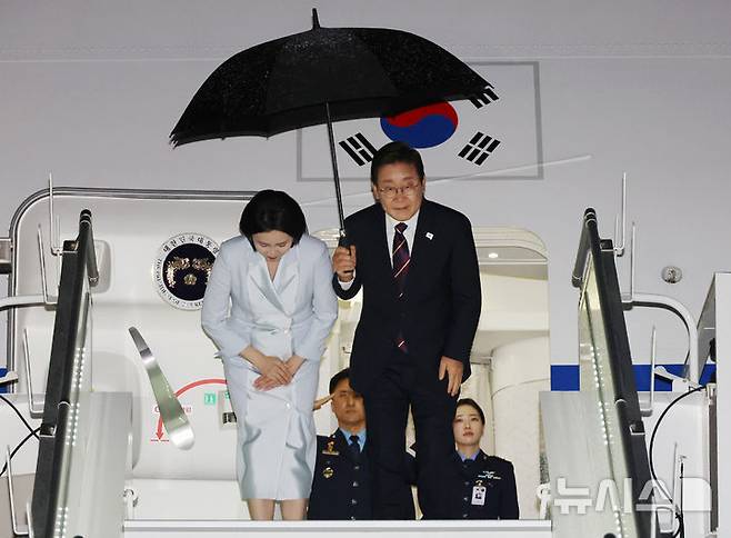 [캘거리=뉴시스] 최진석 기자 = 주요 7개국(G7) 정상회의 참석을 마친 이재명 대통령과 부인 김혜경 여사가 17일(현지 시간) 캐나다 앨버타주 캘거리국제공항에 도착해 공군 1호기에 탑승하며 인사하고 있다. 2025.06.18. myjs@newsis.com