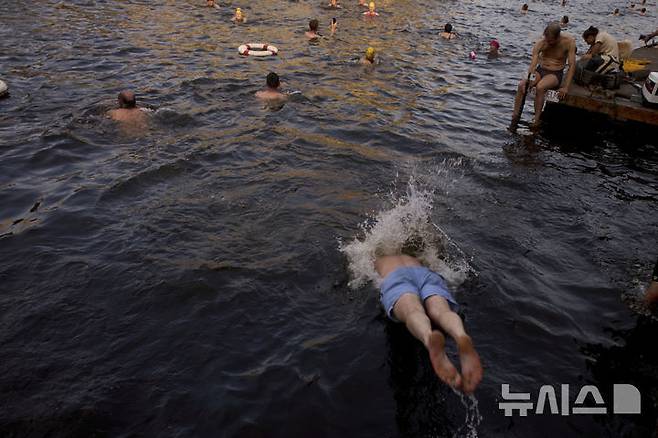 [베를린=AP/뉴시스] 17일(현지 시간) 독일 베를린 슈프레강에서 시민들이 수영 금지 해제를 촉구하며 수영하고 있다. 슈프레강은 수질 오염에 따른 보건 위험으로 100년 넘게 수영이 금지됐으며 강물과 분리된 부유식 수영장만 운영되고 있다. 시민 주도 비영리단체 '플루스바트 베를린'은 슈프레강이 수영할 만큼 수질이 개선됐다면서 수영 허용을 촉구하고 있다. 2025.06.18.