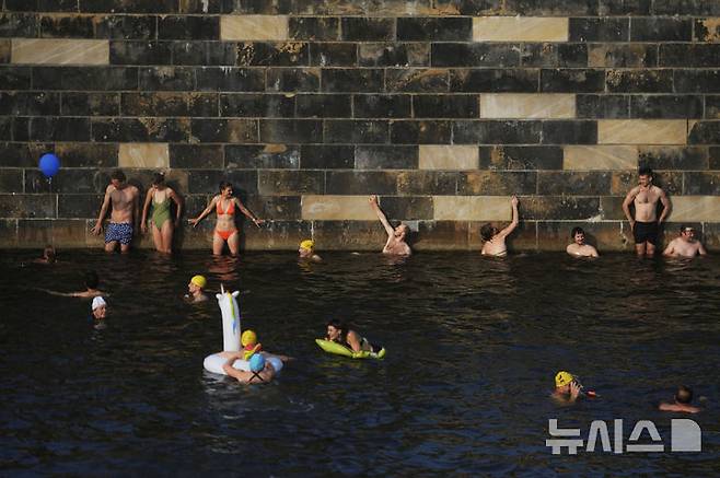 [베를린=AP/뉴시스] 17일(현지 시간) 독일 베를린 슈프레강에서 시민들이 수영 금지 해제를 촉구하며 수영하고 있다. 슈프레강은 수질 오염에 따른 보건 위험으로 100년 넘게 수영이 금지됐으며 강물과 분리된 부유식 수영장만 운영되고 있다. 시민 주도 비영리단체 '플루스바트 베를린'은 슈프레강이 수영할 만큼 수질이 개선됐다면서 수영 허용을 촉구하고 있다. 2025.06.18.