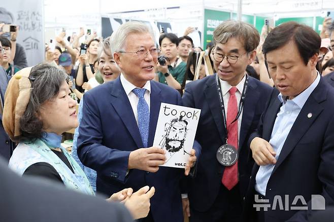 [서울=뉴시스] 박진희 기자 = 문재인 전 대통령이 18일 서울 강남구 코엑스 '2025 서울국제도서전' 평산책방 부스에서 백창화(왼쪽) 작가의 신간을 홍보하고 있다. 2025.06.18. pak7130@newsis.com