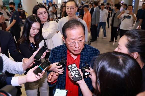 홍준표 전 대구시장이 17일 인천국제공항 제1여객터미널을 통해 귀국해 취재진 질문에 답하고 있다. 홍 전 시장은 국민의힘 대선 후보 경선에서 탈락한 뒤 정계 은퇴를 선언하고 지난 5월 10일 하와이로 출국했다가 한 달여 만에 귀국했다. 연합뉴스