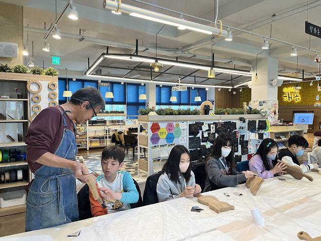 강사님과 함께 재능발견 도마 만들기 중인 학생들. 문화원 제공