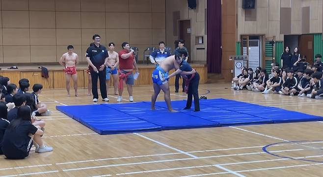 구미출신 씨름천하장사 이태현 대한체육회이사가 지켜보는 가운데 현역씨름선수와 김효진 경사가 광평중 전교생앞에서 씨름기술을 선보였다. /구미경찰서 제공