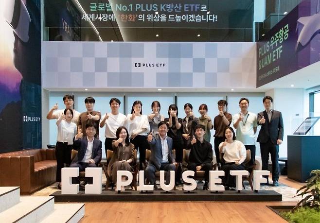 한화자산운용 임직원이 'PLUS K방산 ETF' 순자산 총액이 1조원을 돌파한 것을 기념하며 사진 촬영하고 있다.