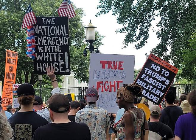 (워싱턴=연합뉴스) 조준형 특파원 = 14일(현지시간) 워싱턴 DC에서 열린 미 육군 창설 250주년 기념 열병식을 앞두고 백악관 인근 라파예트 광장에서 '반(反)트럼프' 시위가 열리고 있다. 참가자들이 “트럼프의 파시스트 열병식에 '노'라고 말하자” 등의 구호가 적힌 피켓을 들고 있다. 2025.6.15. 연합뉴스
