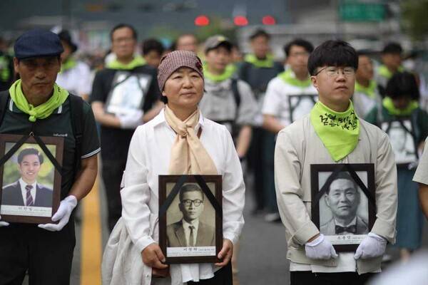지난해 민족민주열사 희생자 범국민추모제에서 이단아(가운데)씨가 부친 영정을 들고 행진하고 있다. 필자 제공