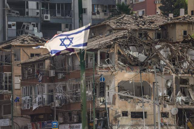 이란 공습으로 파괴된 이스라엘 텔아비브 라마트간 지역에 19일 이스라엘 국기가 펄럭이고 있다. 텔아비브=AFP 연합뉴스