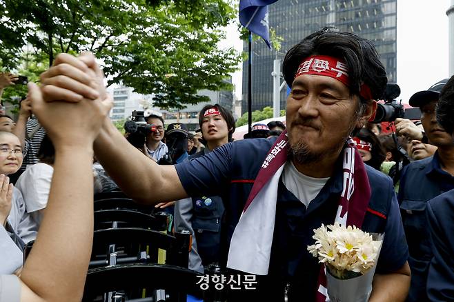 서울 중구 한화빌딩 앞 철탑에 올라 97일째 고공농성을 벌이던 김형수 금속노조 거제통영고성조선하청지회장이 19일 내려와 조합원들과 인사를 나누고 있다. 한화오션 하청노사는 전날 2024년 단체협약을 타결했다. 문재원 기자