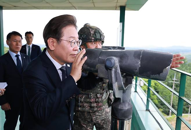 President Lee Jae Myung observes the North through binoculars in Yeoncheon County, Gyeonggi, on June 13. [YONHAP]