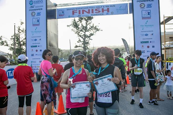 Travelers pose for a photo after completing the Saipan Marathon, which was part of Yellow Balloon tour's package tour. [YELLOW BALLOON TOUR]