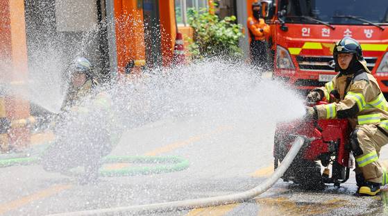 Firefighters at Bupyeong Fire Station in Incheon inspect equipment, such as motor pumps, on June 18 in preparation for possible flooding as the monsoon season approaches. [YONHAP]