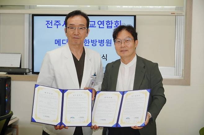 전주시기독교연합회 송시웅 목사(오른쪽)와 메디오투한방병원 박영근 원장이 최근 전주 덕진구 병원에서 열린 협약식에서 협약서에 서명한 뒤 기념촬영을 하고 있다.