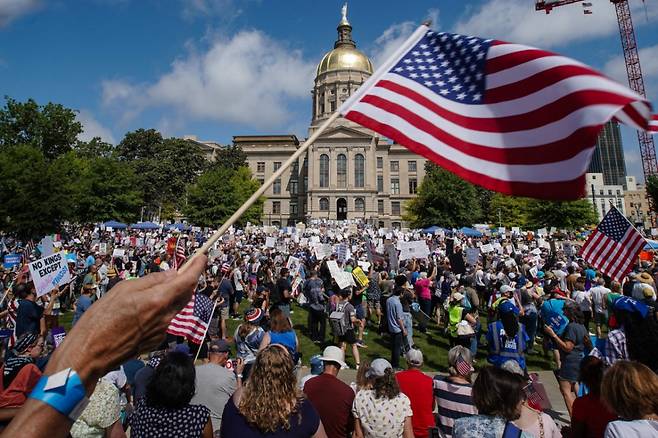 14일(현지시간) 도널드 트럼프 미국 대통령이 워싱턴DC에서 미 육군 창설 250주년 군사 퍼레이드를 주재하는 가운데 이날 조지아주 애틀랜타의 리버티 플라자에서 사람들이 '노킹스'(No Kings) 시위에 참여하고 있다. /AFPBBNews=뉴스1