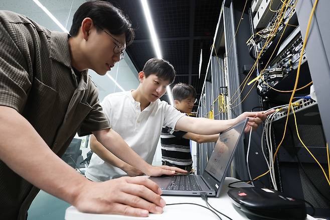 KT 직원들이 차세대 기가 이더넷 스위치(New 5G-GES) 장비를 점검하고 있다. [KT 제공]