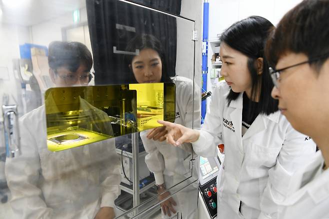 이은숙(왼쪽)·이진형 박사후연구원이 나노 디스크 합성을 위한 임프린팅 장비를 관측하고 있다.[KRISS 제공]