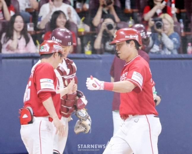 한유섬(오른쪽)이 홈런을 쏘아올리고 홈을 밟고 있다. /사진=강영조 선임기자