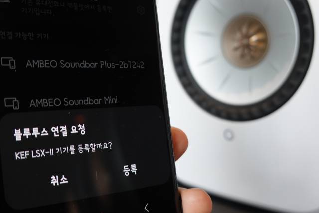 스피커 위에 놓인 리모컨으로 기기 전원을 켜고 스마트폰으로 블루투스를 연결하면 곧바로 음악을 들어볼 수 있다. 기자의 스마트폰에 LSX 2를 연결하는 모습. 조경건 부산닷컴 기자