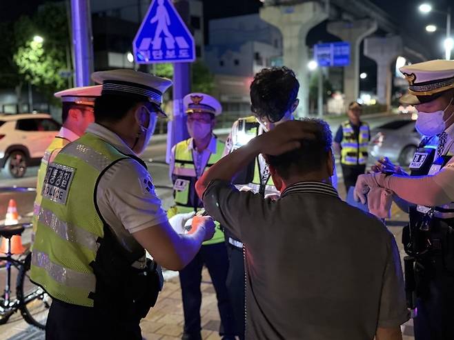 합동음주운전 단속도중 혈중알콜농도 0.063%로 면허정지 100일 처분을 받은 50대 남성 A씨가 현장 경찰관의 안내를 받고 있다. 구경모기자