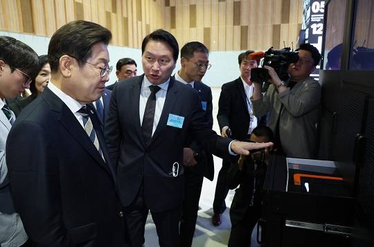 이재명 대통령이 20일 울산전시컨벤션센터에서 열린 AI글로벌 협력 기업 간담회에서 AI제품 및 서비스 시연을 참관하며 최태원 SK그룹 회장의 설명을 듣고 있다. 사진=뉴시스