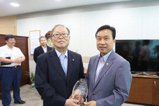 2013년 8월 7일 이충재 당시 행정중심복합도시건설청장(오른쪽)이 정부세종청사 6-3동 행복청장실에서 강용식 전 행복도시건설추진위원회 자문위원장에게 감사패를 전달하는 모습. 행정중심복합도시건설청 제공