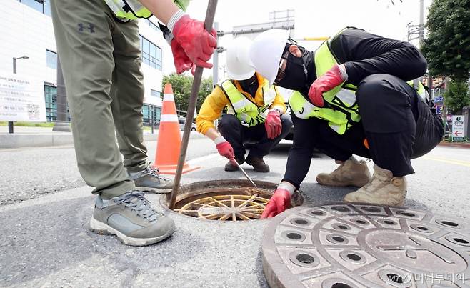 지난 17일 오전 광주 북구 용봉동 한 교차로에서 북구 하천방재과 하수팀 직원들이 추락사고를 사전 예방하기 위해 맨홀 추락방지 안전망을 점검하고 있다. 기사와 직접적인 관련 없는 자료 사진. /사진=뉴시스(광주 북구 제공).