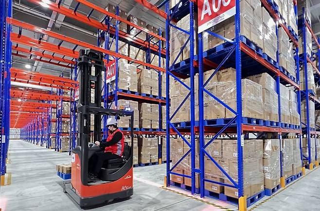 징둥로지스틱스 인천물류센터의 한 근로자가 전동식 지게차로 물건을 옮기고 있다.   [징둥로지스틱스 제공]