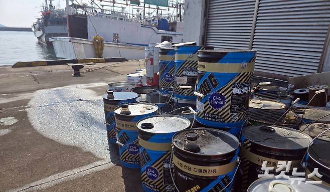 시설 밖까지 쌓인 기름통들. 인근에 어선들이 정박해 있다. 이창준 크리에이터