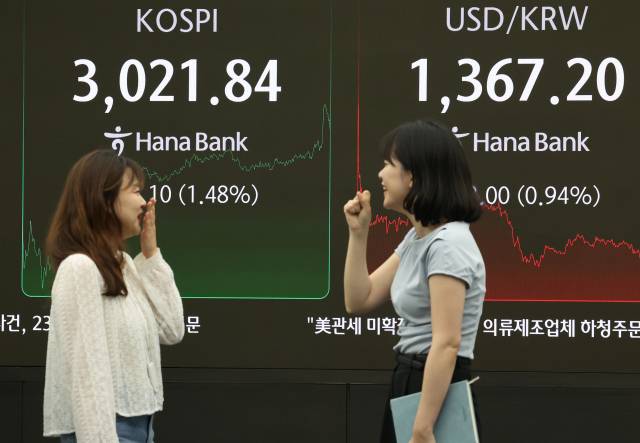 20일 서울 중구 하나은행 딜링룸에서 딜러들이 대화하고 있다. 연합뉴스