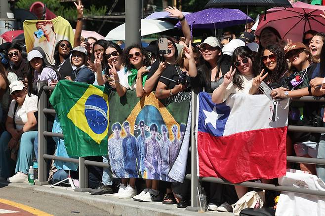 방탄소년단(BTS) 멤버 지민과 정국의 전역일인 11일 서울 용산구 하이브 사옥 앞에서 국내외 아미(ARMY·BTS의 팬덤)들이 제대를 축하하고 있다. 연합뉴스