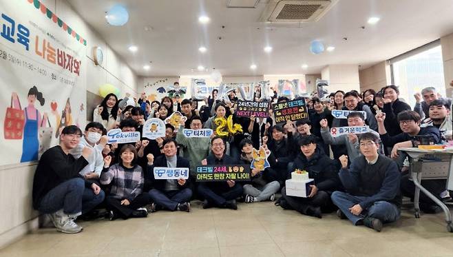테크빌교육이 24주년 창립기념일을 맞아 자선바자회를 열고 임직원 단체 사진을 촬영하는 모습. (사진=테크빌교육)