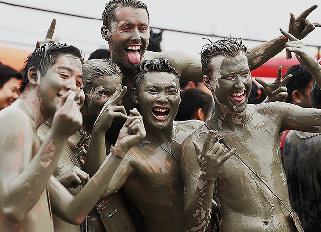Visitors covered in mud pose for a photo during the 2024 Boryeong Mud Festival. (Courtesy of Boryeong City)