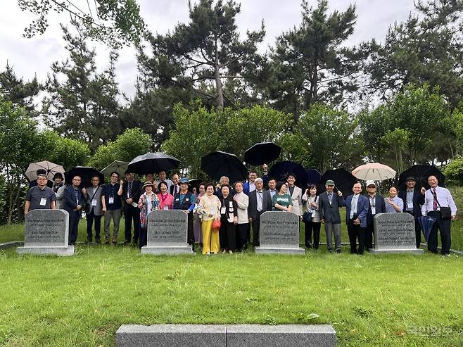 전국 각지에서 온 세계성시화운동본부 관계자들이 4인의 선교사 묘비 뒤에 서서 기념 사진을 찍고 있다.
