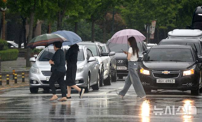 [전주=뉴시스] 김얼 기자 = 전북지역 곳곳에 호우주의보가 내려진 21일 전주시 백제대로에서 시민들이 우산으로 비를 피하며 길을 지나고 있다. 2025.06.21. pmkeul@newsis.com