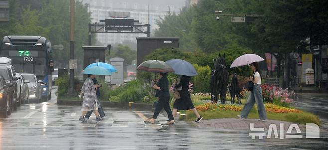 [전주=뉴시스] 김얼 기자 = 전북지역 곳곳에 호우주의보가 내려진 21일 전주시 백제대로에서 시민들이 우산으로 비를 피하며 길을 지나고 있다. 2025.06.21. pmkeul@newsis.com