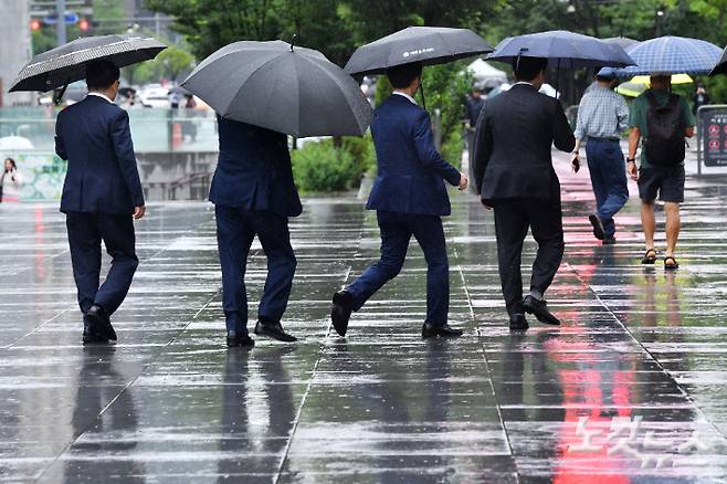 올 여름 본격적인 장마가 시작된 20일 오전 서울 종로구 광화문 광장에서 우산을 쓴 시민들이 발걸음을 재촉하고 있다. 류영주 기자