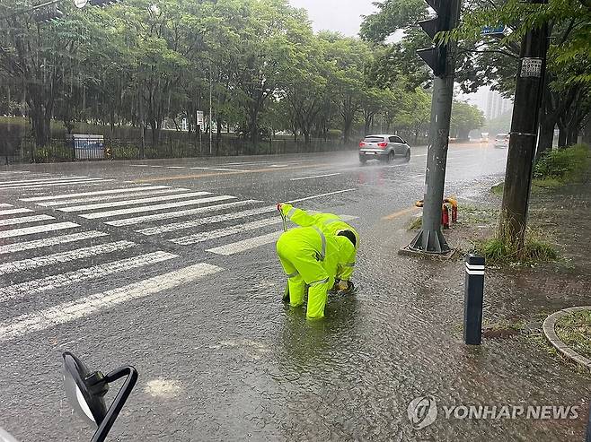 폭우에 들뜬 맨홀 긴급 정비 (광주=연합뉴스) 21일 광주 광산구 첨단2동에서 광산구 관계자들이 폭우로 이탈한 맨홀 뚜껑을 정비하고 있다. 2025.6.21 [광주 광산구 제공. 재판매 및 DB 금지] iny@yna.co.kr