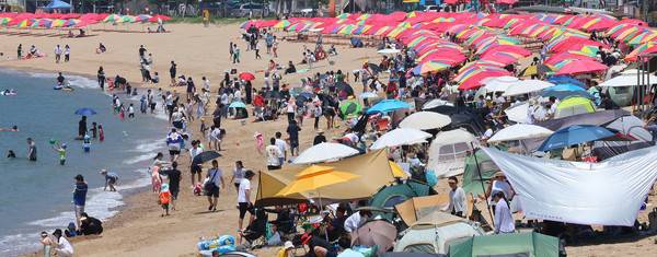 장마가 잠시 소강 상태를 보인 22일 인천 중구 왕산해수욕장을 찾은 시민들이 더위를 식히고 있다. 2025.6.22. [사진=연합뉴스]