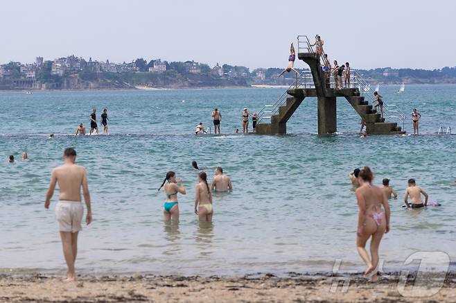 유럽 대륙에 때 이른 폭염이 찾아오며 프랑스 서부 일부 지역의 낮 최고 기온이 섭씨 38도, 체감온도는 40도를 기록한 가운데, 21일(현지시간) 프랑스 북서부 브르타뉴 지방의 생말로 해변을 찾은 시민들이 다이빙 등 해수욕을 하며 더위를 식히고 있다. 2025.6.22/뉴스1 ⓒ News1 이준성 기자