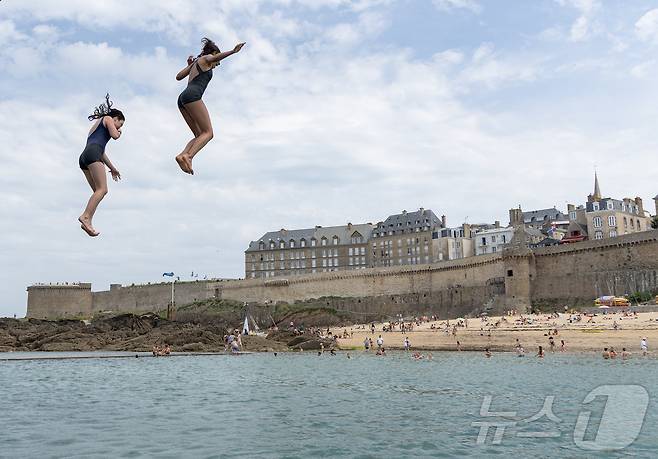 유럽 대륙에 때 이른 폭염이 찾아오며 프랑스 서부 일부 지역의 낮 최고 기온이 섭씨 38도, 체감온도는 40도를 기록한 가운데, 21일(현지시간) 프랑스 북서부 브르타뉴 지방의 생말로 해변을 찾은 시민들이 다이빙 등 해수욕을 하며 더위를 식히고 있다. 2025.6.22/뉴스1 ⓒ News1 이준성 기자