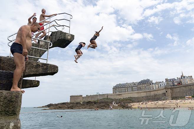 유럽 대륙에 때 이른 폭염이 찾아오며 프랑스 서부 일부 지역의 낮 최고 기온이 섭씨 38도, 체감온도는 40도를 기록한 가운데, 21일(현지시간) 프랑스 북서부 브르타뉴 지방의 생말로 해변을 찾은 시민들이 다이빙 등 해수욕을 하며 더위를 식히고 있다. 2025.6.22/뉴스1 ⓒ News1 이준성 기자