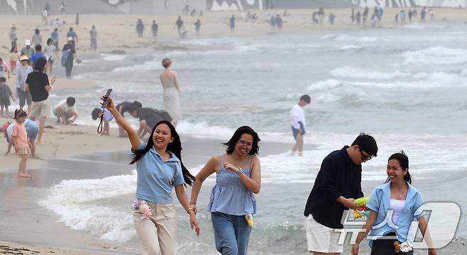 부산 해운대해수욕장이 개장한 후 첫 주말을 맞은 22일 해운대해수욕장을 찾은 외국인 관광객들이 해변을 거닐며 활짝 웃고 있다. 2025.6.22/뉴스1 ⓒ News1 윤일지 기자