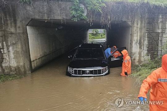 지난 20일 오전 경기 고양시 대화동의 한 지하차도에서 차량이 침수돼 소방대원들이 운전자를 구조하고 있다. [사진=연합뉴스]