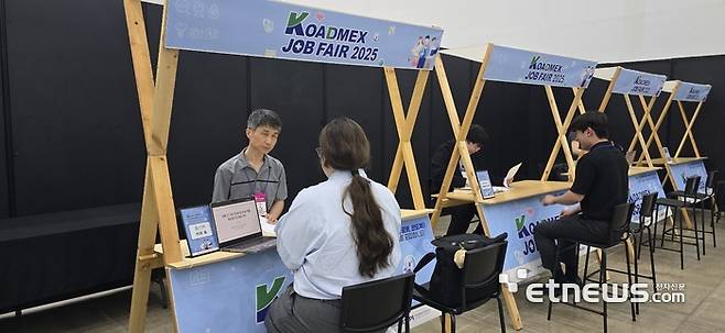 'KOADMEX 잡페어 2025'에서 구인기업 담당자와 구직자가 인터뷰를 진행하고 있다.