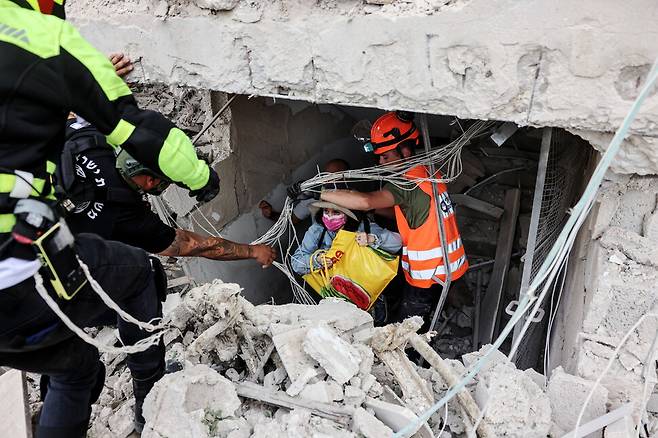 이란의 미사일 공격으로 피해를 입은 텔아비브 시내에서 구조 인력이 주민들을 긴급 대피시키고 있다. 로이터연합뉴스