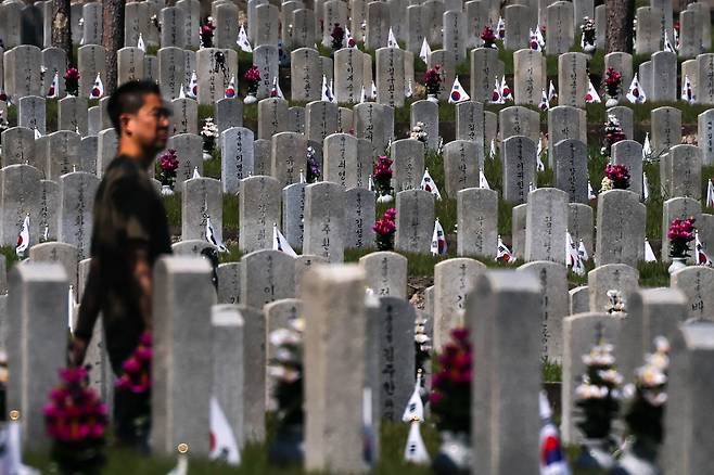 6·25전쟁 75주년을 사흘 앞둔 22일 서울 동작구 국립서울현충원 묘역을 찾은 한 시민이 묘비 사이를 걷고 있다. 성동훈 기자