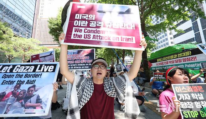 [서울=뉴시스] 추상철 기자 = 트럼프 미국 대통령이 이란의 주요 핵 시설을 파괴했다고 밝힌 22일 오후 서울 종로구 교보빌딩 인근에서 열린 노동자연대의 '전쟁 중단 및 이스라엘 공격 규탄집회'에서 집회 참가자가 피켓을 들고 전쟁 중단을 촉구하고 있다. 2025.06.22. scchoo@newsis.com